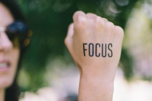 A woman's fist on which is written the word "focus"