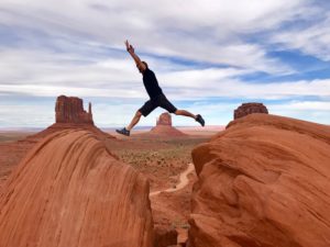 energetic man jumping on canyon