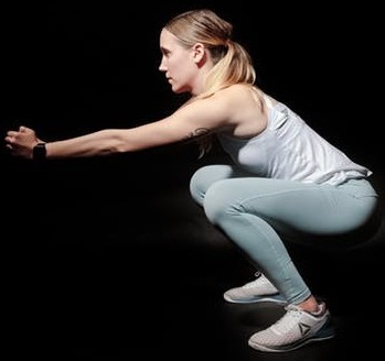 Compound exercise. A woman is squatting.