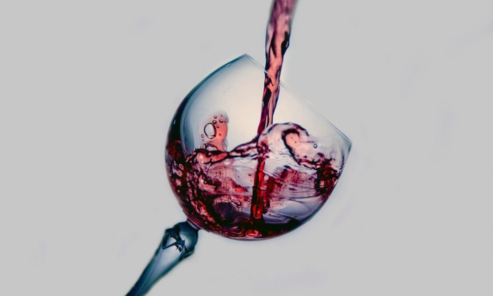 Some red wine being poured in a wine glass