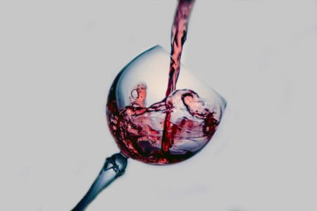 Some red wine being poured in a wine glass