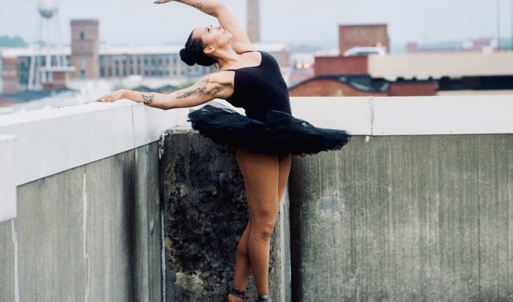 A ballerina with a tatoo in a black tutu