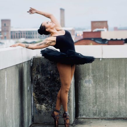 A ballerina with a tatoo in a black tutu