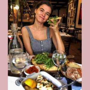 A woman at a restaurant eating mediterranean food