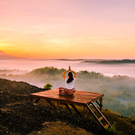 rest days-woman doing yoga watching sunset