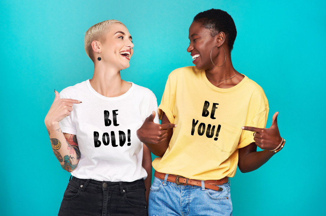 gaining self-confidence-studio shot of two young confident women  pointing at their t-shirts statements