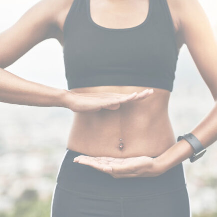 Strong Core Benefits-Close-up shot of a sporty woman holding her hands against her core
