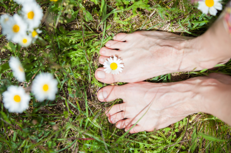 Health benefits of earthing. Bare feet in grass.