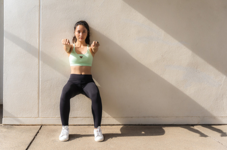 strong legs-woman doing wall sit exercise