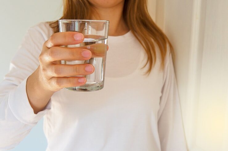 French winter body skincare tips-a woman holding a glass of water to drink