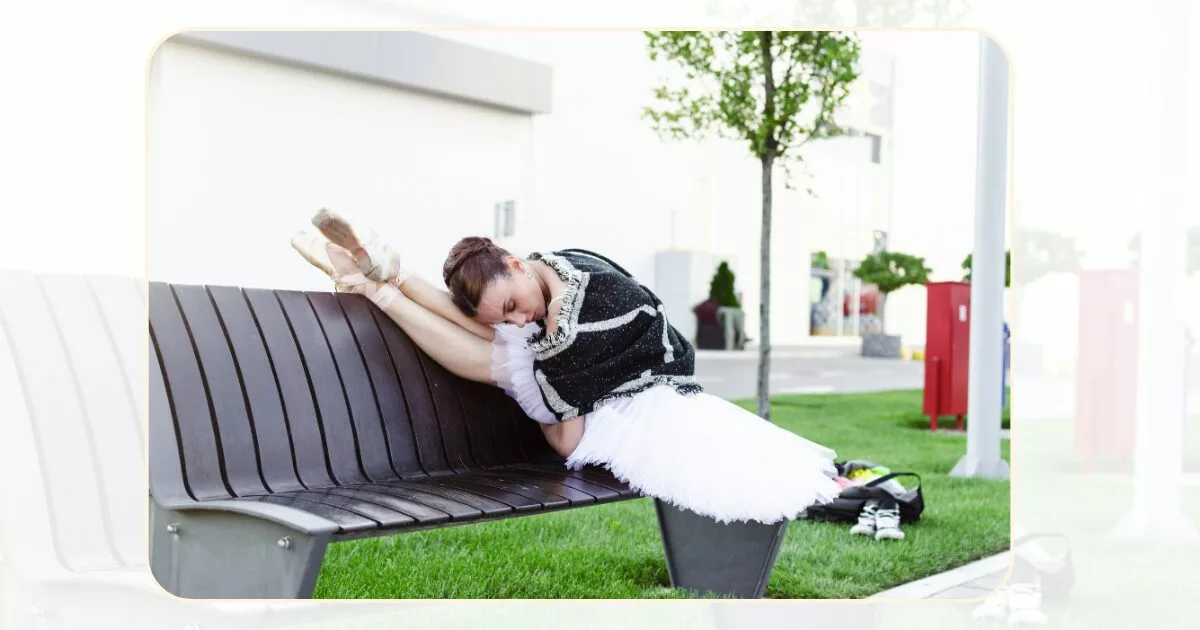 Ballet dancer stretching on a bench in the street