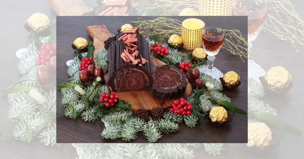 yule french christmas chocolate decorated cake with winter flora, alcoholic drink, candle on rustic oak wood background