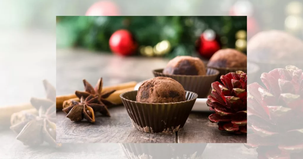 french christmas dark chocolate truffles with winter flora and winter spices on dark oak wood and christmas decor background